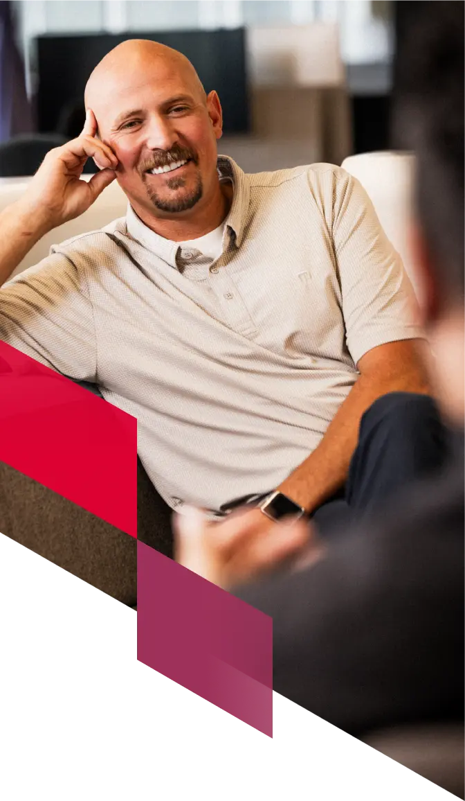 A locums physician smiles while sitting and relaxing.